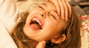 Ein Mädchen lacht über einen lustigen Aprilscherz